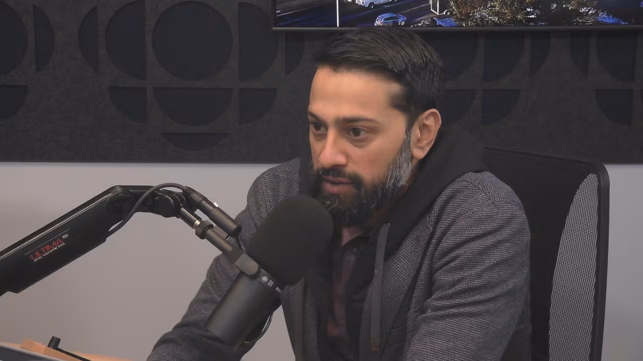 Vijai Krishnaswamy speaking into a microphone